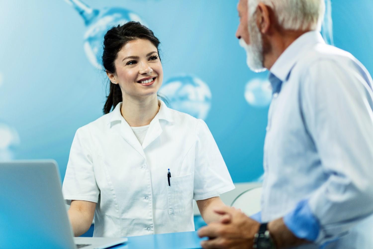 Healthcare professional speaking with an older man